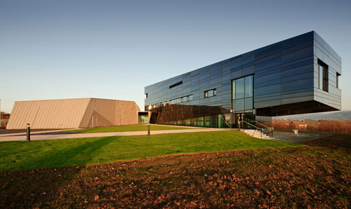 The Dalton Cumbrian Facility, a modern, angular building, set in the countryside with a clear sky in the background.