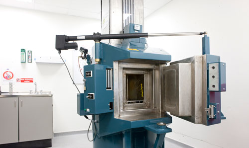 The high-dose rate gamma irradiator, a blue metal machine, in the centre of a large white room.